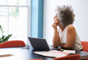 woman sitting with laptop, thinking